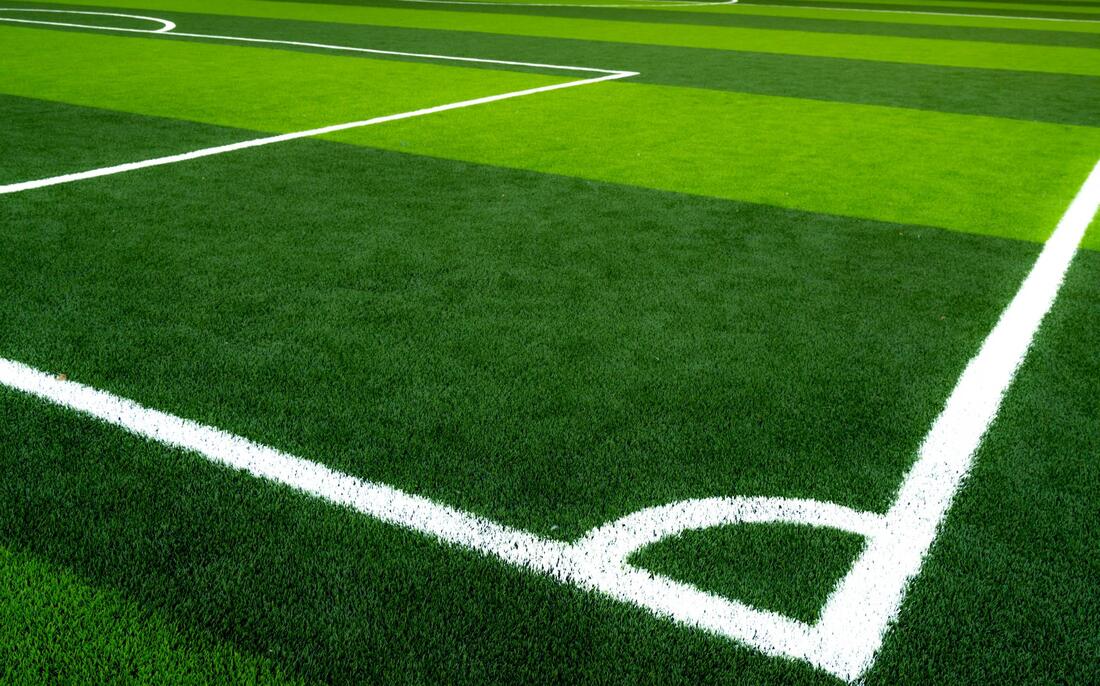 artificial grass or artificial turf soccer field with freshly painted lines on it